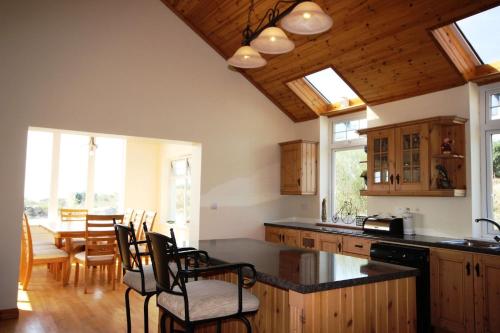 eine Küche mit Holzschränken und einem Tisch und Stühlen in der Unterkunft The Uplands in Spiddal