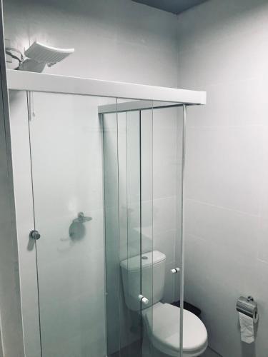 a bathroom with a toilet and a glass shower at Conforto entre a UFSM e o centro in Santa Maria