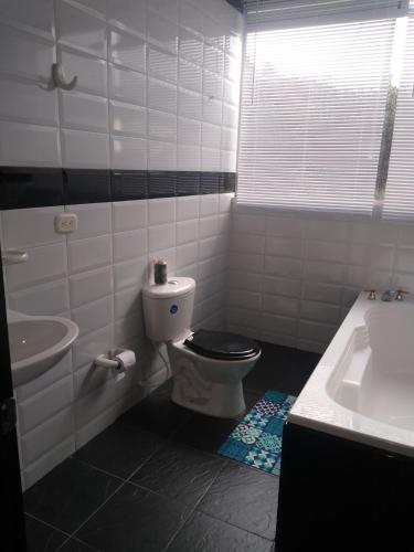 a bathroom with a toilet and a sink at Hospedaje Gratitud Guatavita in Guatavita