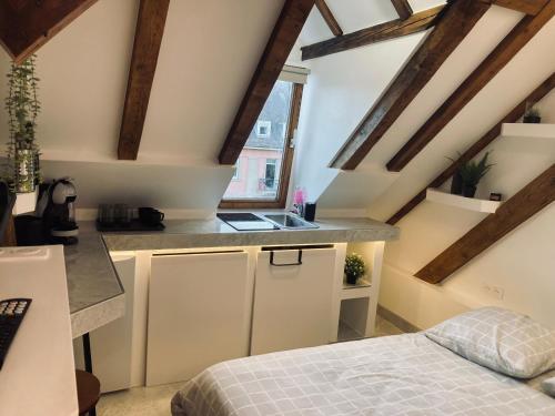 Habitación con cama y cocina con vigas de madera. en Petit nid sympa a Strasbourg, en Estrasburgo