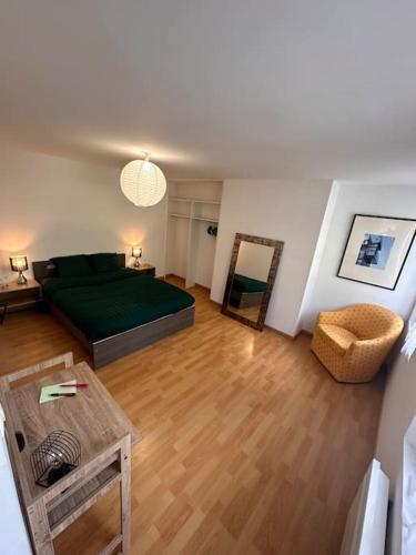 - un salon avec un lit vert et une table dans l'établissement T3 Confortable à Abbeville - Baie de Somme, à Abbeville