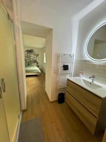 La salle de bains est pourvue d'un lavabo et d'un lit dans la chambre. dans l'établissement Appartement en centre-ville - Local vélos disponible, à Mayenne