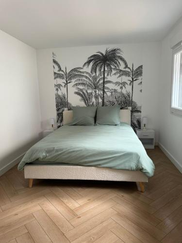 - une chambre avec un lit recouvert de palmiers dans l'établissement Appartement en centre-ville - Local vélos disponible, à Mayenne