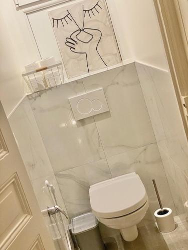 Elle comprend une petite salle de bains pourvue de toilettes et d'une photo. dans l'établissement Appart in Paris, à Pantin