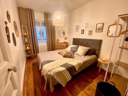 une chambre avec un lit sur lequel est allongé un chat dans l'établissement Appart in Paris, à Pantin