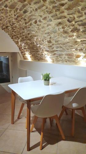 - une table et des chaises blanches dans la chambre dans l'établissement Le poulailler, à Blesle