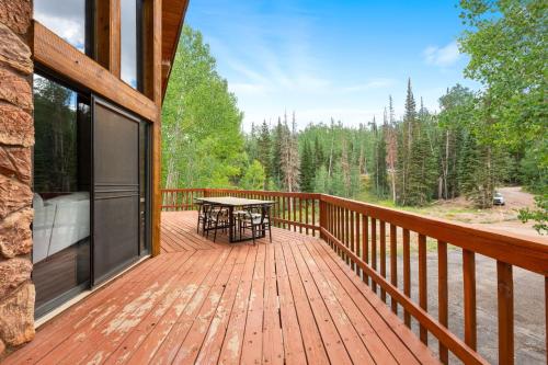 a wooden deck with a table and chairs on it at Arcade Games Brian Head Resort Newly Renovated in Brian Head