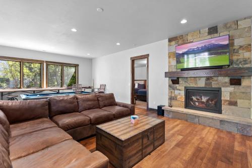 a living room with a couch and a fireplace at Snowghost Chalet Ultimate Luxury Ski In Ski Out 5BD 55BA with Hot Tubs Steam Room and Game Room in Whitefish