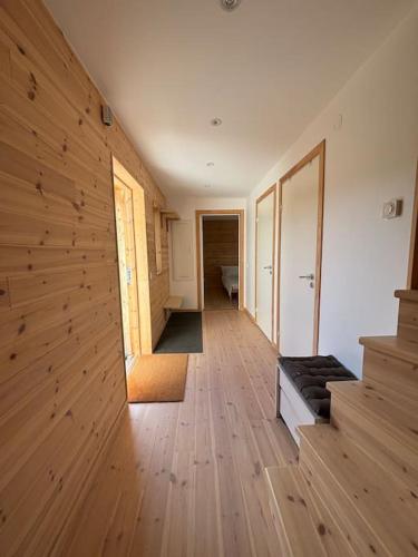 a room with wooden floors and a room with a hallway at Wonderful barn cabin in Järvsö Harsa in Järvsö