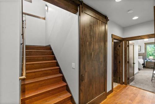 a staircase in a house with a wooden door at Snowghost Chalet Ultimate Luxury Ski In Ski Out 5BD 55BA with Hot Tubs Steam Room and Game Room in Whitefish