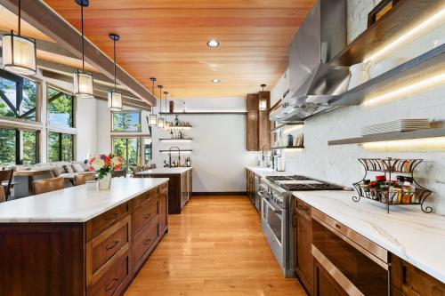 a large kitchen with wooden floors and wooden cabinets at Snowghost Chalet Ultimate Luxury Ski In Ski Out 5BD 55BA with Hot Tubs Steam Room and Game Room in Whitefish