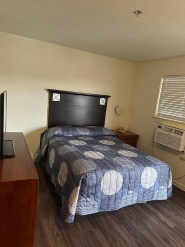 a bedroom with a bed and a desk and a television at My Town Extended Stay in Nashville