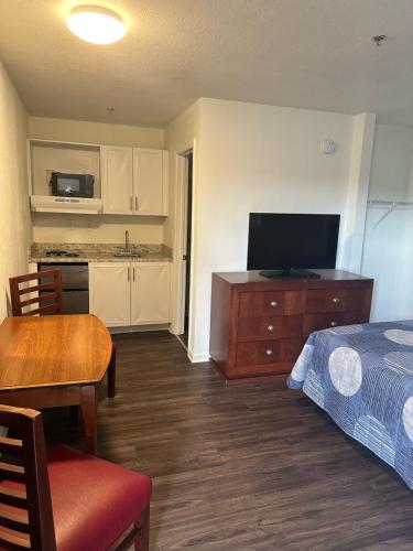 a room with a bed and a kitchen with a television at My Town Extended Stay in Nashville