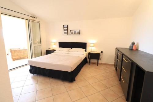 a bedroom with a bed and a large window at Sardegna Appartamento panoramico cod IUN Q4795 in Orosei