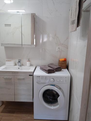 a washing machine in a bathroom with a sink at Fish eye in Nikiti