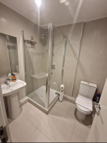 a bathroom with a shower and a toilet and a sink at En-suites Suites - Leeds City Retreat with Kitchenette- LGI Hospital- Free 5G WIFI & Netflix- University - Contractors - Short Stays in Leeds