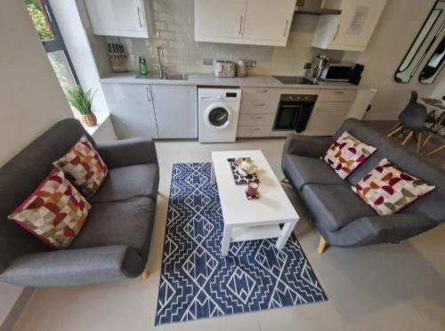 a living room with two couches and a table at En-suites Suites - Leeds City Retreat with Kitchenette- LGI Hospital- Free 5G WIFI & Netflix- University - Contractors - Short Stays in Leeds