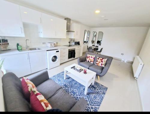 a living room with a couch and a table at En-suites Suites - Leeds City Retreat with Kitchenette- LGI Hospital- Free 5G WIFI & Netflix- University - Contractors - Short Stays in Leeds