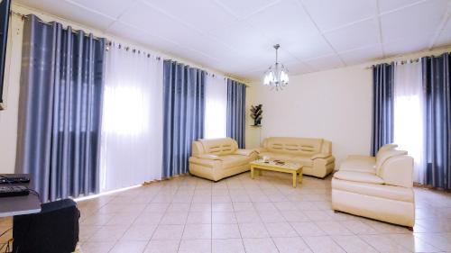 a large living room with two chairs and a table at Inkindi House in Kigali
