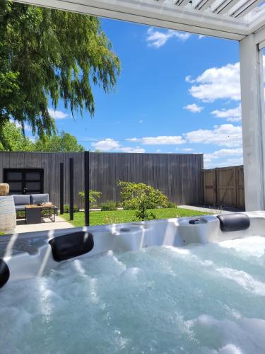 a jacuzzi tub in the backyard of a house at Hedone - Overnachting met wellness in Heuvelland