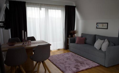 a living room with a couch and a table with chairs at Ferienhaus Del Mondo am Wörthersee in Velden am Wörthersee