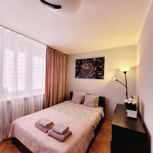 une chambre avec un lit avec deux serviettes dessus dans l'établissement Apartament Centrum Warszawa, à Varsovie