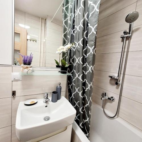 une salle de bain blanche avec lavabo et douche dans l'établissement Apartament Centrum Warszawa, à Varsovie