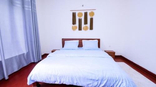 a bedroom with a large bed with white sheets at Inkindi House in Kigali