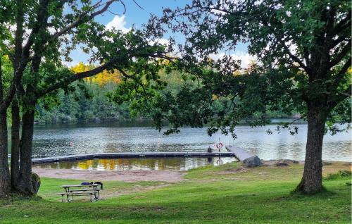 a park bench next to a lake with a dock at 2 Bedroom Nice Home In Ankarsrum in Ankarsrum
