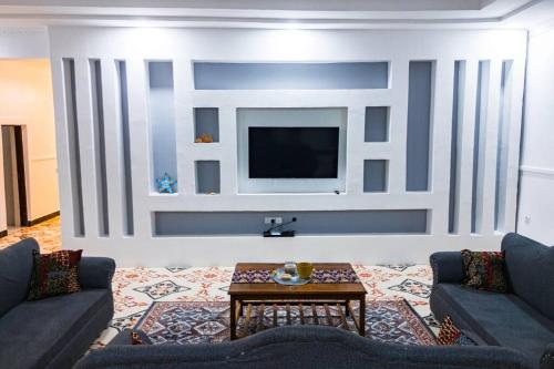 a living room with two couches and a tv at Bahari Bliss in Makunduchi