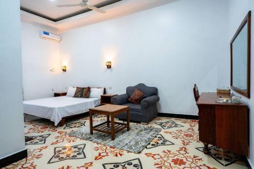 a bedroom with a bed and a couch in a room at Bahari Bliss in Makunduchi