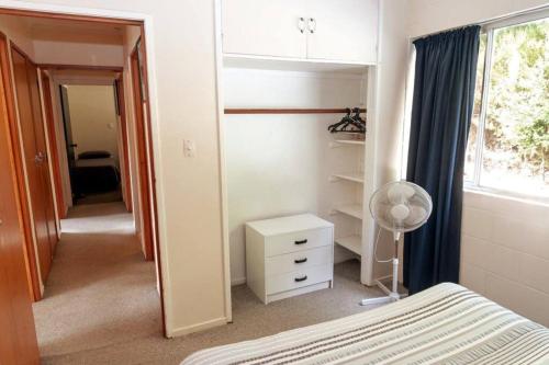 a bedroom with a bed and a desk and a window at Spacious House or Units near town Low cost in Paihia