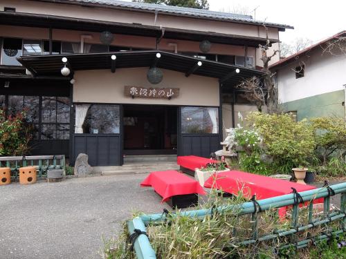 un edificio con mesas rojas delante de él en Yamanokami Onsen, en Nagano