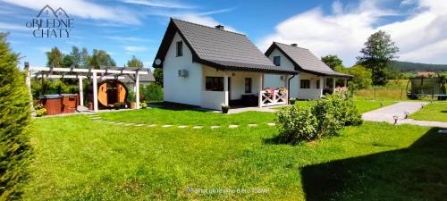 a small house in a yard with a green lawn at oBłędne Chaty in Wünschelburg