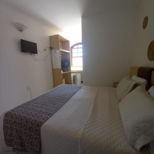a bedroom with a large bed and a window at Casa Hospedagem Diamantina in Diamantina