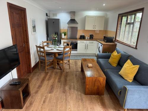 a living room with a blue couch and a table at Garden flat in London in London