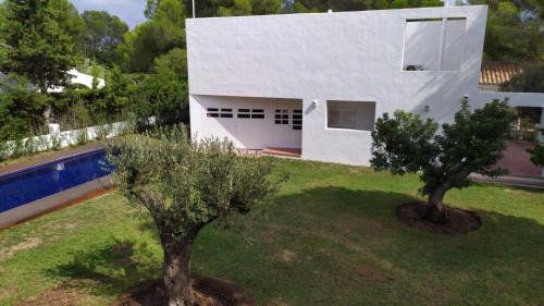 a white house with two trees in front of it at Xalet Argany in Sant Jordi d'Alfama in Les tres Cales
