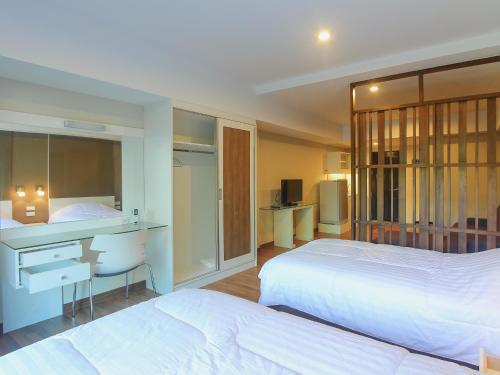 a hotel room with two beds and a desk and a desk at Huahin City View in Hua Hin