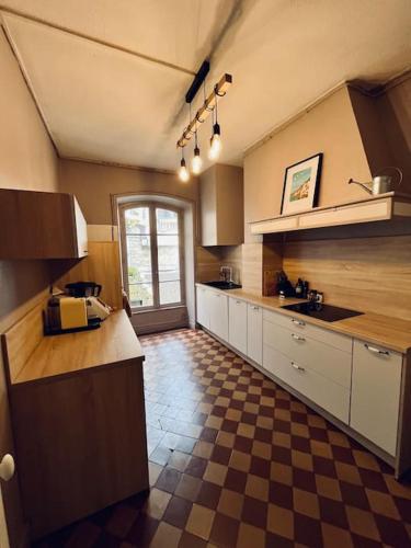 - une grande cuisine avec un sol en damier dans l'établissement T3 Charmant, à Limoges