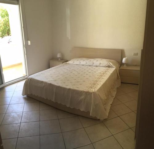 Un pat sau paturi într-o cameră la Appartamento Oristano 21