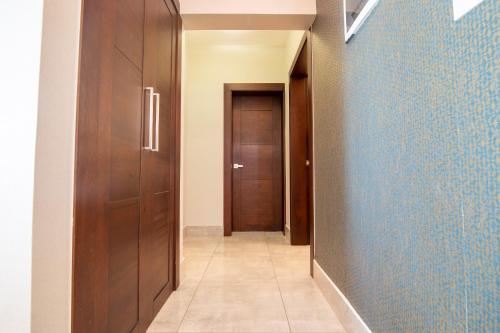 a hallway with a blue wall and wooden doors at Exclusivo apartamento - Soha Suites II-B9 - 2 BR in Rincón Largo