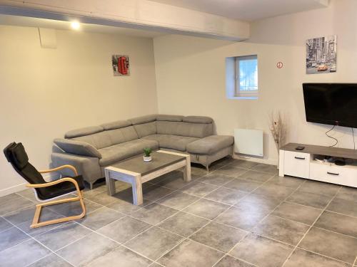 a living room with a couch and a tv at A&J Family - Neuvy sur Loire - Guédelon in Neuvy-sur-Loire