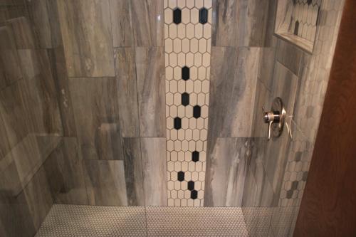 a bathroom with a shower with a tiled floor at Little Creek Cove Beach Resort in Newport