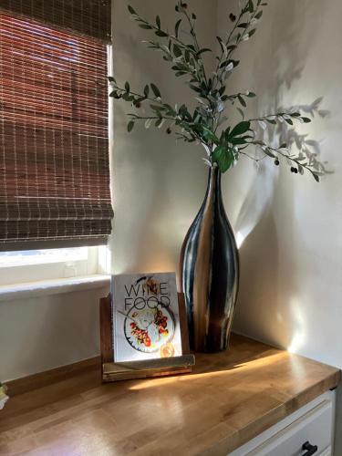 a vase and a book on a table with a vase and a plant at Casita Needles with Jacuzzi, Firepit, Boat Parking in Needles