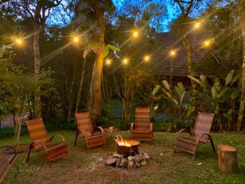 a group of chairs around a fire pit at night at Casa da Pedra Atibaia Clube da Montanha in Atibaia