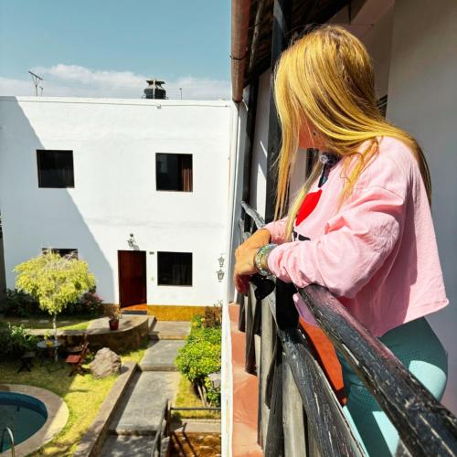 a woman looking out of a balcony of a house at La casa de theo in Arequipa