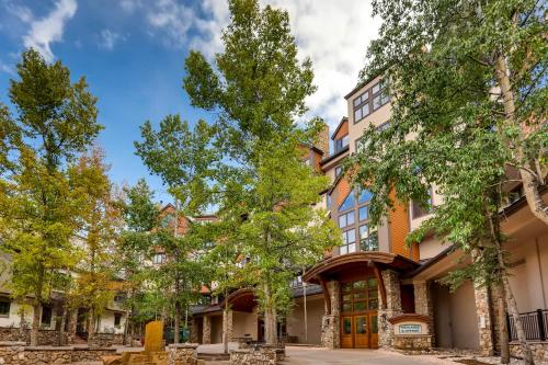 an apartment building with trees in front of it at Highlands Slopeside 505 by East West Hospitality in Beaver Creek