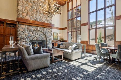a large living room with a stone fireplace at Highlands Slopeside 505 by East West Hospitality in Beaver Creek