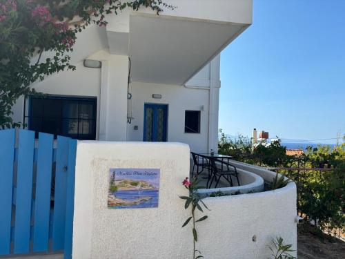 a white building with a fence and a sign on it at Mochlos Thea Thalatta in Mochlos