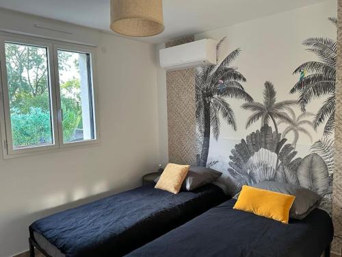 - une chambre avec 2 lits et une fresque murale de palmiers dans l'établissement Green home Paris Disneyland, à Chalifert
